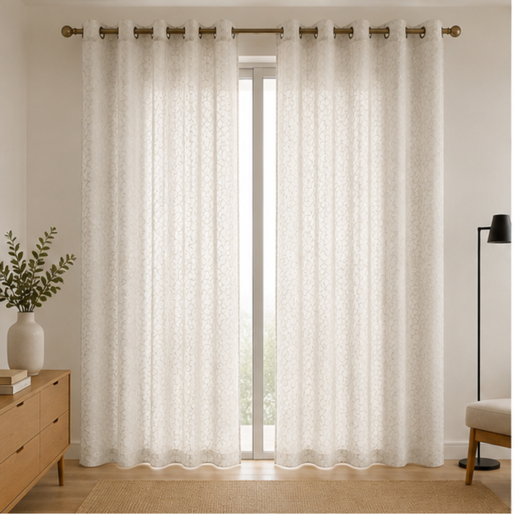 A pair of Pearl white textured grommet curtains hanging on a gold curtain rod in a bright, modern room setting.