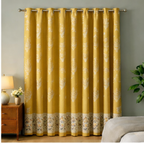 Yellow floral curtains with a gray wall and wooden nightstand in the background