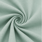 A close-up of mint green fabric arranged in a spiral drape, showing a subtle repeating tonal pattern.